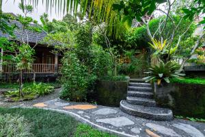 a garden with a stone path and a house at Yeh Pulu House in Ubud +17 photos