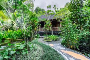 a garden with a house in the background at Yeh Pulu House in Ubud