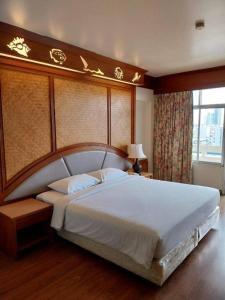 Un dormitorio con una cama grande con un cabecero grande. en Golden Beach Hotel Pattaya, en Pattaya central