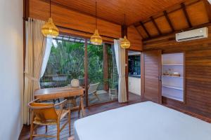 a bedroom with a desk and a table and chairs at Yeh Pulu House in Ubud