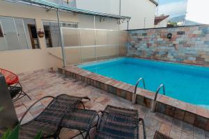 a swimming pool with chairs next to a house at Pousada do Chafariz in Mariana