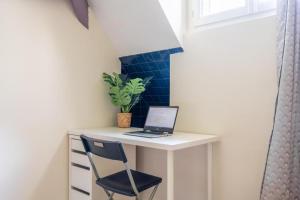 a desk with a laptop and a chair in a room at Appart 8 personnes Jardin Parkings Voitures Vélos,10min Château,40min Zoo Beauval in Blois