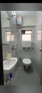 a bathroom with a white toilet and a sink at Pinaki Vile parle west in Mumbai