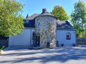 une maison avec une tour en pierre avec un garage dans l'établissement Apartamenty Karkonosze U Mirosława - JAGNIĄTKÓW, à Jelenia Góra