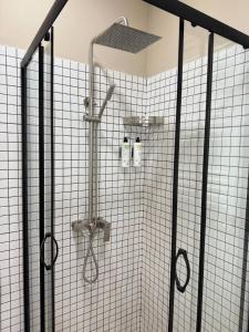 a shower in a bathroom with white tiled walls at Tbilisi Rooftop in Tbilisi City