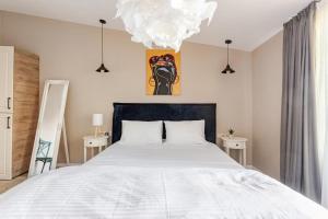 a bedroom with a large white bed and a chandelier at Tbilisi Rooftop in Tbilisi City