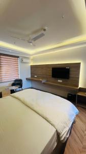 a bedroom with a bed and a flat screen tv at Casa Nova Luxury Studio and Prime Location in Greater Noida