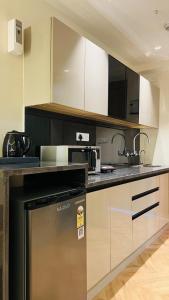 a kitchen with white cabinets and a stainless steel dishwasher at Casa Nova Luxury Studio and Prime Location in Greater Noida