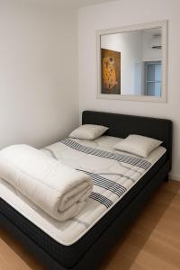 un grande letto in una stanza con specchio di Studio Entièrement Rénové Rue Grande Haute, Sète a Sète