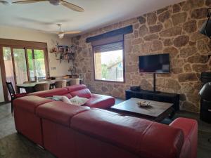 a living room with a red couch and a stone wall at "La Casa del Pueblo" - La Vera - AT-CC-00451 in Viandar de la Vera