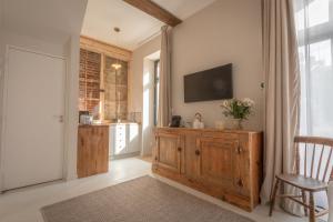 ein Wohnzimmer mit einem TV und einem Holzschrank in der Unterkunft Les Écuries de Juranville in Bourges