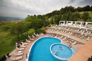 an overhead view of a swimming pool with chairs and umbrellas at Apartment - Studio Cucetno in Sandanski