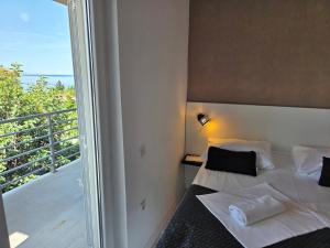 a bedroom with a bed and a balcony at Bed & Breakfast Dora in Rovanjska