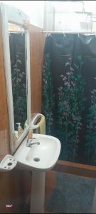 a bathroom with a sink and a shower with a mirror at Hospedaje Los Buenos Aires in Santa Ana