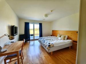 a bedroom with a bed and a table and a desk at Baldersnäs Herrgård in Dals Långed