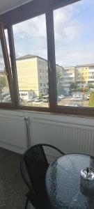 a table and a chair in front of a window at Escapadă urbană, confort, curte privată și parcare in Piatra Neamţ