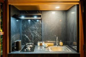 a kitchen counter with a sink and a stove at Yeh Pulu House in Ubud