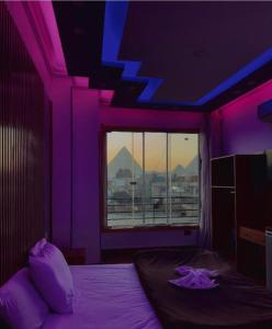 a purple room with a bed and a window at Continental de las pirámides in Cairo