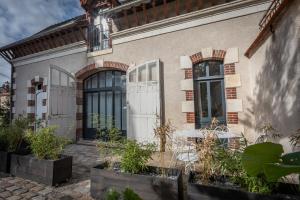 ein Haus mit einer Terrasse und einem Tisch im Freien in der Unterkunft Les Écuries de Juranville in Bourges