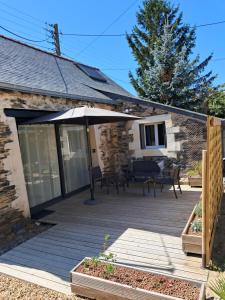 a patio with an umbrella and a table and chairs at LOFT #5 Angers Loire in Corné
