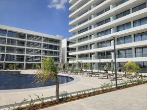 a large apartment building with a courtyard with a pool at Holiday Apartments at Grand Sapphire Residence in Saint Yeorgios