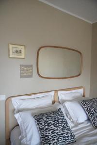a bed with white pillows and a mirror on a plane at Casa Mare - Sea View, Home Cinema, Parking in Menton
