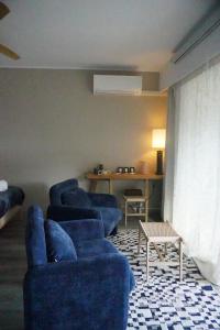 a living room with two blue chairs and a table at Casa Mare - Sea View, Home Cinema, Parking in Menton