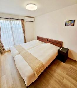 a bedroom with a large bed with a blanket on it at Mulan Stay 松尾大社 in Kyoto