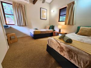 a bedroom with two beds and a couch at Splendid 705 Cooloola Villa, Kingfisher Bay K'gari Fraser Island in Kingfisher Bay +61 photos