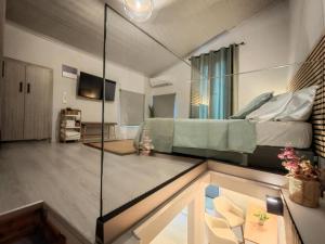 纳夫普利翁La maison verte NAFPLIO的一间带床和玻璃墙的客厅