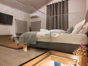 a bedroom with a bed with a glass wall at La maison verte NAFPLIO in Nafplio