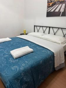 a bed with two white towels on top of it at Easy Room Italy Central Station in Milan