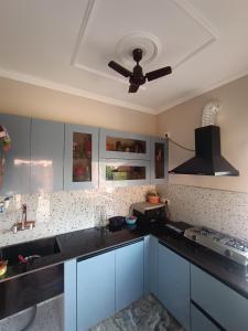 eine Küche mit weißen Schränken und einem Deckenventilator in der Unterkunft The family courtyard in Amritsar