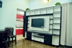 Un centro de entretenimiento con televisión en una habitación. en Mysuru Family Home Stay, en Mysore
