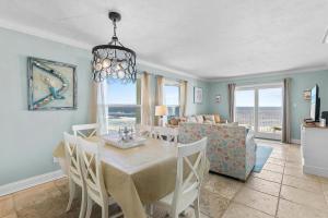 a dining room and living room with a table and chairs at Sea Coast Gardens II 401 in New Smyrna Beach