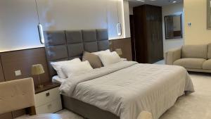 Un dormitorio con una cama grande y un sofá. en Ajman Executive Stay, en Ajman