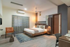 una stanza d'albergo con un letto e una sedia di Hotel Serenity La Vista a Hyderabad Altre 48 foto