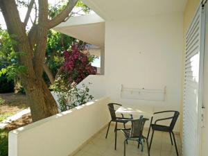 a patio with a table and chairs and a tree at Ledakis Studios in Frangokastello