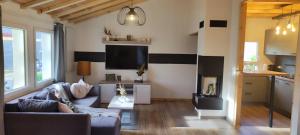 a living room with a couch and a table and a kitchen at Ferienhaus Hexenhäuschen in Walhausen
