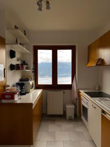 a kitchen with a view of the ocean from a window at Landscapesilvia Acqua in Menaggio