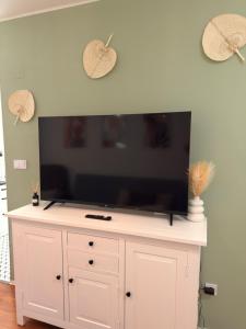 a flat screen tv sitting on top of a white cabinet at City Center & Free Parking - Rest & Nest Boho Deluxe Apartment in Debrecen