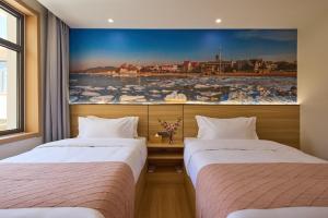 Ένα ή περισσότερα κρεβάτια σε δωμάτιο στο Floral Hotel Beidaihe Migao Intelligent Hotel