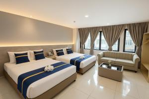 a hotel room with two beds and a couch at StarQ Hotel Kuala Lumpur in Kuala Lumpur +44 photos