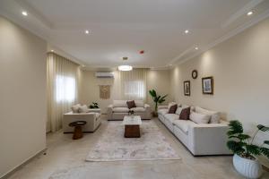 a living room with white couches and a rug at Welhome Stays Aparthotel in Cairo