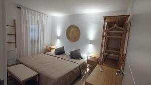カラン・ポルテルにあるEl Escape - confort y calmaの小さなベッドルーム(ベッド1台、木製の棚付)