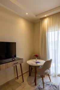 a living room with a tv and a table and a table sidx sidx at Welhome Stays Aparthotel in Cairo +36 photos