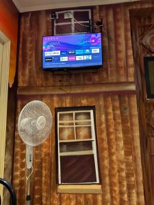 a room with a television and a fan and a window at Hotel Santiago Yungay in Santiago