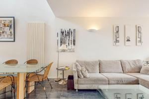 una sala de estar con un sofá y una mesa en St Agne 3 min du métrobus - Patio - bassin, en Toulouse