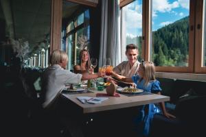 a family sitting at a table in a restaurant at Almhof Family und Wellness Resort in Gerlos