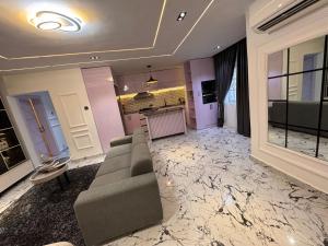 a living room with a couch and a kitchen at Adonai Luxury Apartment in Port Harcourt +16 photos